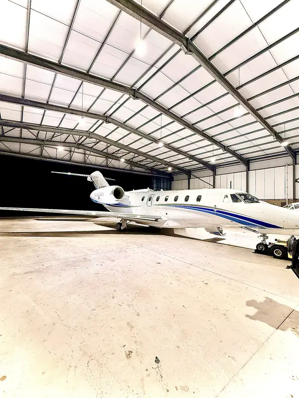 Citation X inside a brightly lit hangar at night